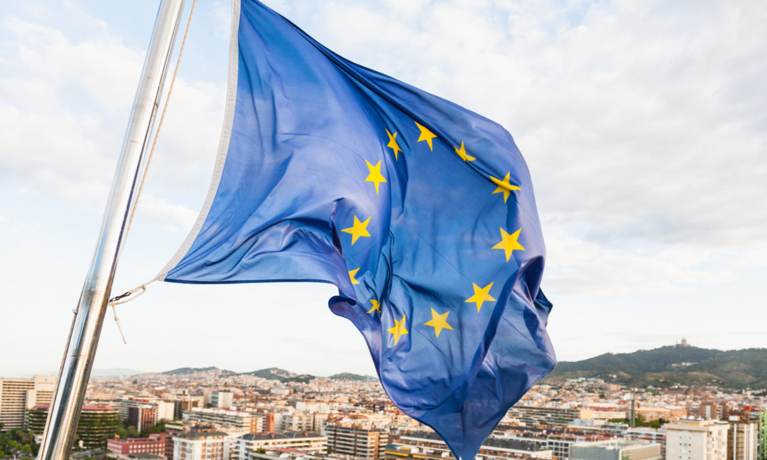 EU flag fluttering by wind above Barcelona